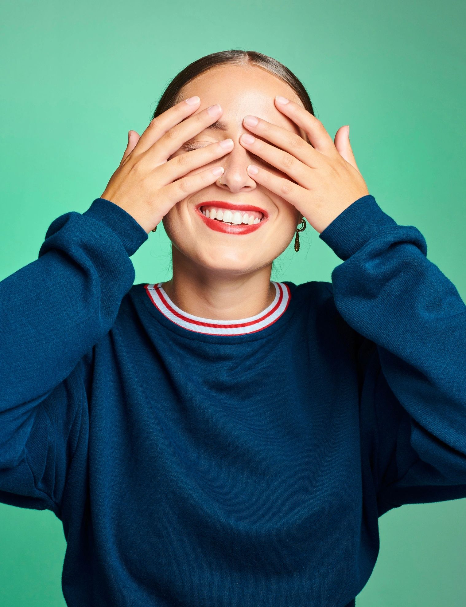 Woman smiling brightly with hands near her face