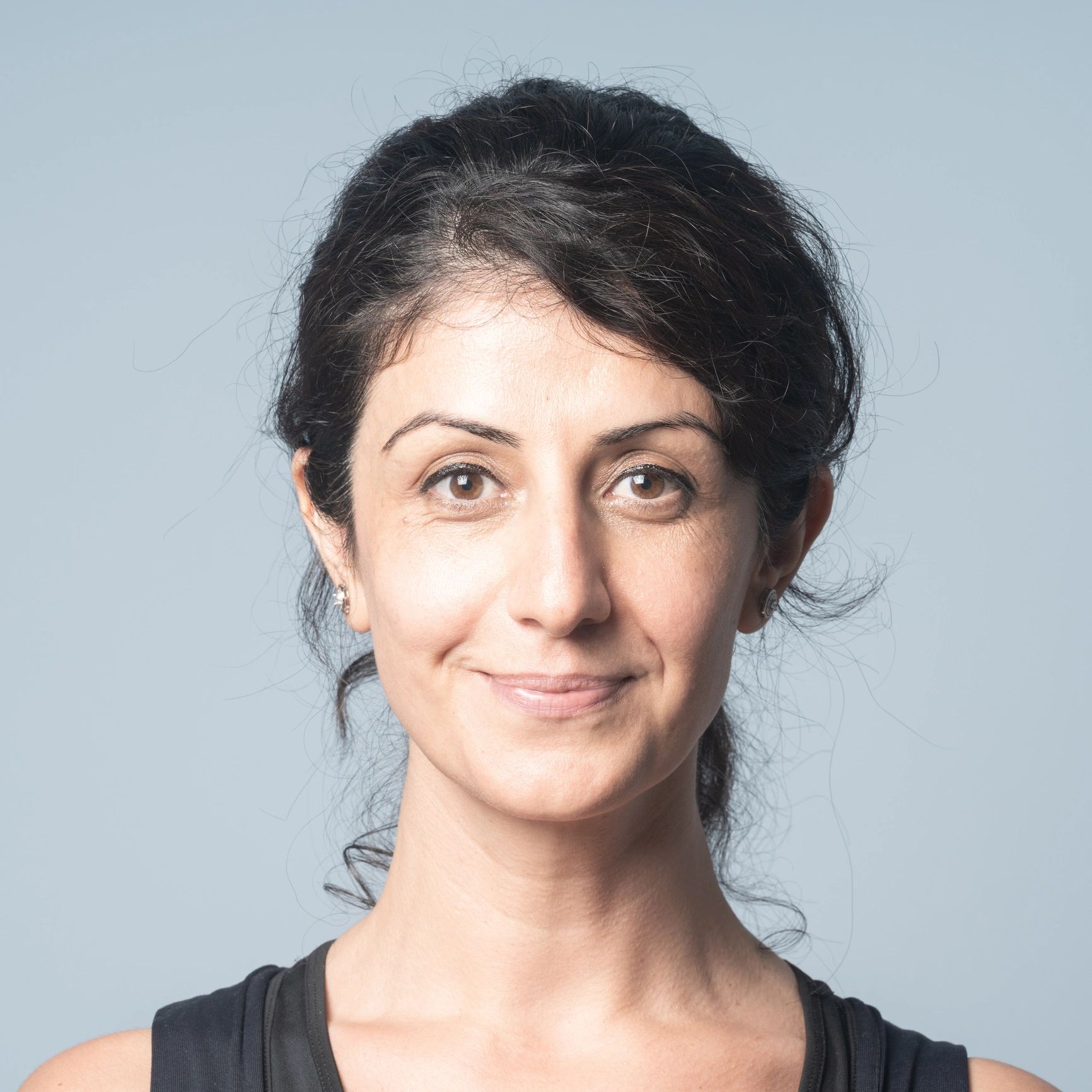 Confident woman smiling in studio against blue background